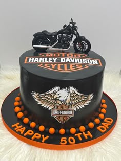 a harley davidson birthday cake with an orange motorcycle on top