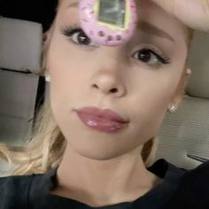 a woman holding up a cell phone with a pink donut on it's face