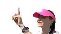 a woman wearing a pink hat and visor points her finger up