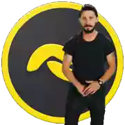 a man in a black shirt stands in front of a yellow circle with a wave on it