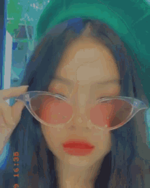 a close up of a woman wearing sunglasses with red lips