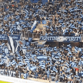 a crowd of people in a stadium with a sign that says fightin spirit
