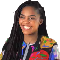 a woman with dreadlocks and a colorful jacket is smiling