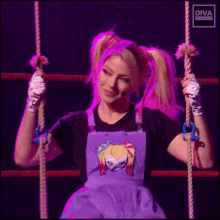 a woman in overalls is holding a rope in a ring .