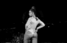 a black and white photo of a woman in a bikini on a stage .
