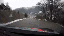 a car is driving down a snowy road with a fia logo on the dashboard