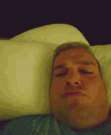 a man laying on a bed with a pillow on his head