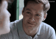 a man is crying while looking at another man 's face and the word guitar is on the bottom right