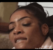 a close up of a woman 's face with her eyes closed