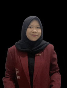 a woman wearing a red jacket with the word tmu on the front