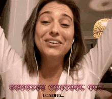 a woman wearing headphones is smiling with the words sending virtual hug loading