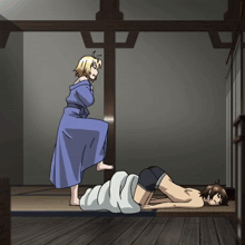 a woman in a blue robe is standing next to a man laying on a bed