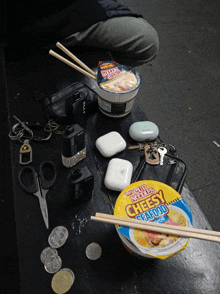 a bowl of cup noodles sits on a table next to chopsticks