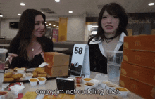 two women are sitting at a table in front of a mcdonald 's table number 58