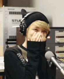 a person wearing headphones covering their face in front of a stuck box