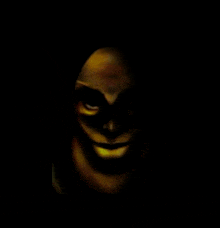 a close up of a person 's face with a smile on it 's face in the dark .