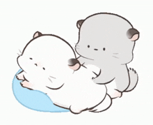 two cartoon cats are laying on top of each other on a pillow .