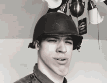 a man wearing a military helmet has a tag on his head that says ' military ' on it