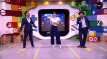 three people are dancing in front of a screen that says the net