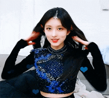 a woman is sitting on a couch with her hands in her hair and hearts around her .