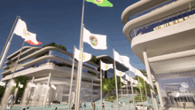 a group of flags are flying in front of a building with a green flag
