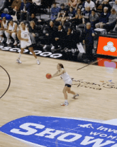 a basketball game is being played on a court with a sign that says show