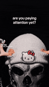 a skeleton wearing a hello kitty beanie asking if they are paying attention