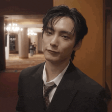 a man in a suit and tie looks at the camera