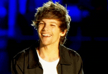 a young man in a black jacket and white shirt smiles