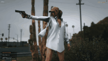 a woman in a white shirt is holding a gun in front of a cactus