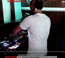 a man wearing headphones and a white shirt is playing a dj set .