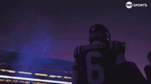 a football player with the number 6 on his jersey stands in front of a tnt sports logo