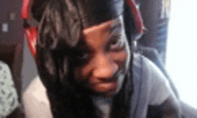 a close up of a woman wearing headphones and making a funny face .