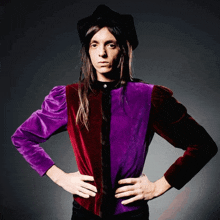 a man with long hair wearing a red and purple jacket