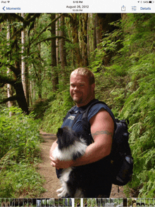 a picture of a man holding a dog with the date august 2012 on it
