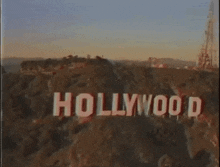 an aerial view of the hollywood sign on top of a hill at sunset .