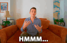 a man is sitting on a couch with the word hmm written on it