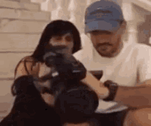 a man and a woman are sitting next to each other holding a camera .