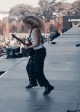 a woman is playing a guitar on a stage