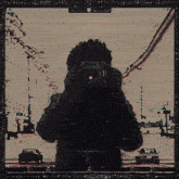 a picture of a person taking a picture of a city street with a bus that says ' boston transit ' on the side