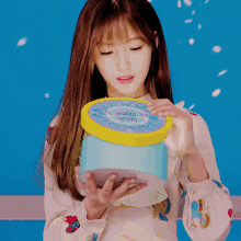 a woman is holding a container that says london sweets