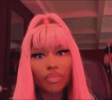 a close up of a woman with pink hair and a fringe .