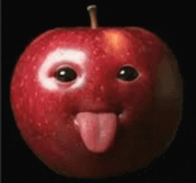 a red apple with a face on it sticking its tongue out .