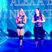 two women are standing in front of a wall that says alexa ink ck