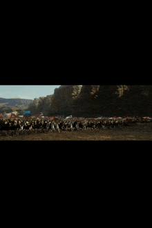 a blurred image of a herd of cows running in a field
