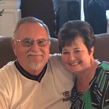 a man and woman are posing for a picture and the man is wearing a jersey that says georgia