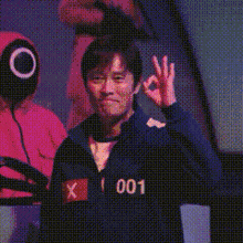 a man in a squid game costume is holding a yellow ring .