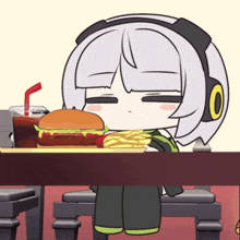 a girl with headphones is eating a hamburger and french fries at a table