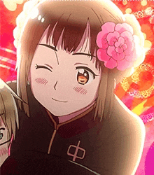 a girl with a pink flower in her hair is smiling and looking at the camera .