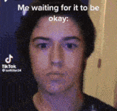 a close up of a man 's face with the caption `` me waiting for it to be okay '' .